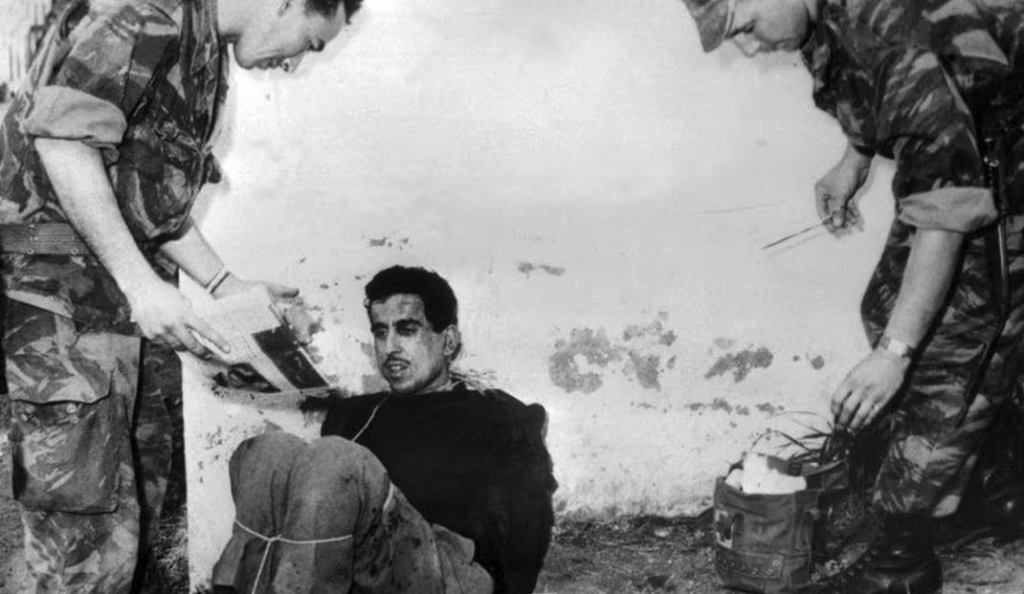 Omar Merouane, membre du FLN et de ses groupes de choc pendant la bataille d’Alger, est interrogé sans ménagement par les parachutistes, le 14 mars 1957 (©AFP)